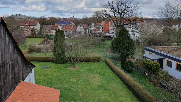 A residential area with houses, a grassy yard, and a wooden barn.