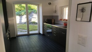 Cocina moderna con un amplio ventanal corredera que da a un jardín.