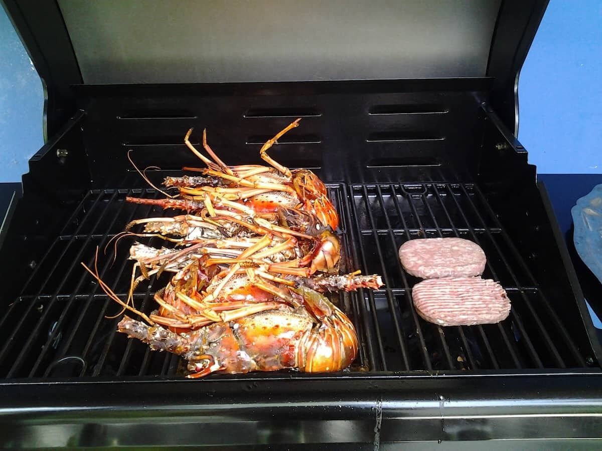 A grill with seafood and burgers.