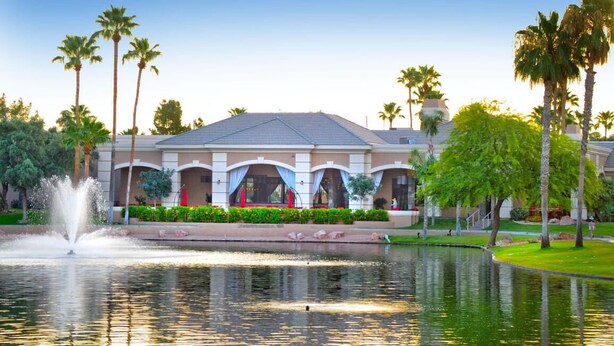 A hotel with a fountain, palm trees, and a pool. - Gorgeous Oakwood Vacation Home with Golf Cart! Spotless!!! (Sun Lakes)