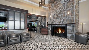 A lobby with a stone fireplace, leather seating, and a patterned floor. - Gorgeous Oakwood Vacation Home with Golf Cart! Spotless!!! (Sun Lakes)