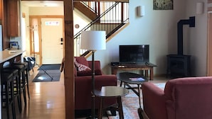 Ein gemütliches Wohnzimmer mit Kamin, einer Treppe und einem Essbereich.