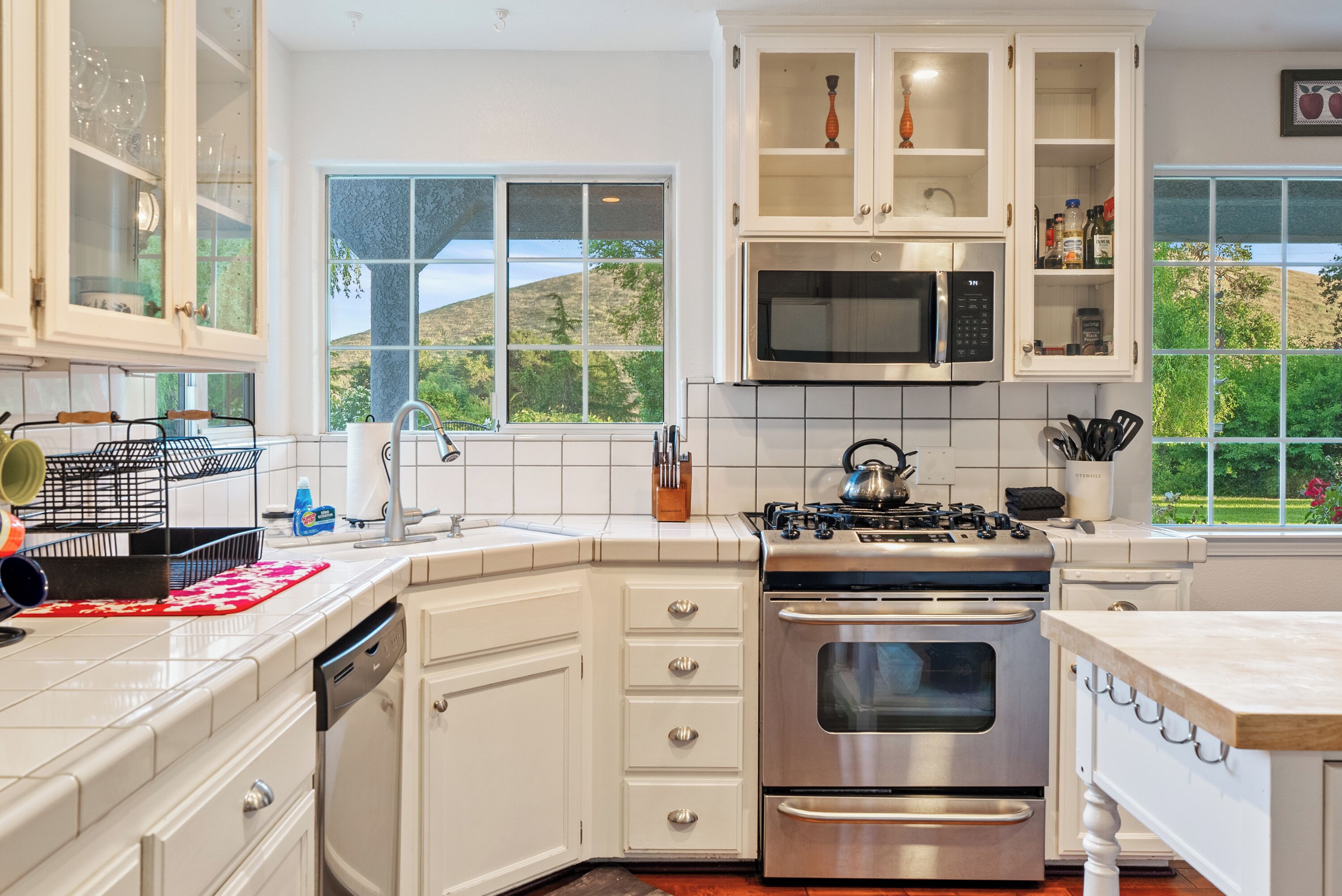 A modern kitchen with white cabinetry, stainless steel appliances, and a view of the outdoors.