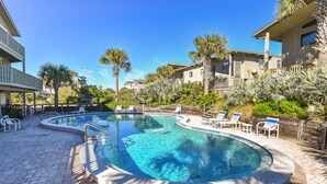 A swimming pool with lounge chairs and palm trees. - Sunnyside Up Townhome at Sea Dunes - Ocean View & Next to Pool - B6 Up (New Smyrna Beach)