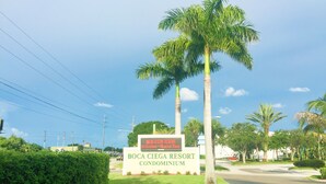 Señal de Boca Ciega Resort Condominium con cielo despejado y palmeras.