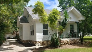 A single-story house with a stone foundation, a covered porch, and a paved driveway. - Getaway New Smyrna Beach, Sun, Pool, Shopping. (New Smyrna Beach)