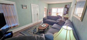 A living room with a sofa, a coffee table, and a lamp. - Getaway New Smyrna Beach, Sun, Pool, Shopping. (New Smyrna Beach)