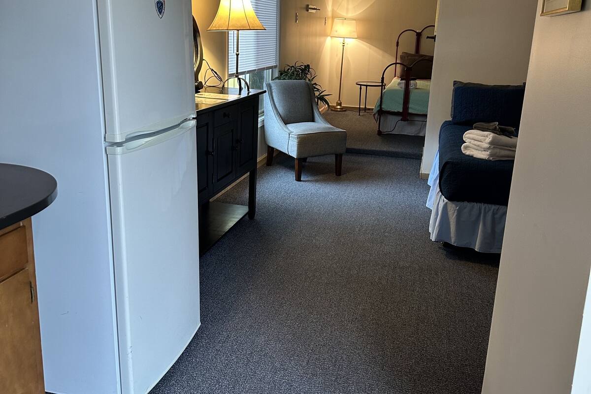 A compact living space with a kitchenette, a dining area, and a bedroom.