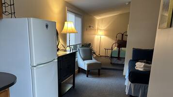 Un espacio habitable compacto con kitchenette, comedor y habitación.