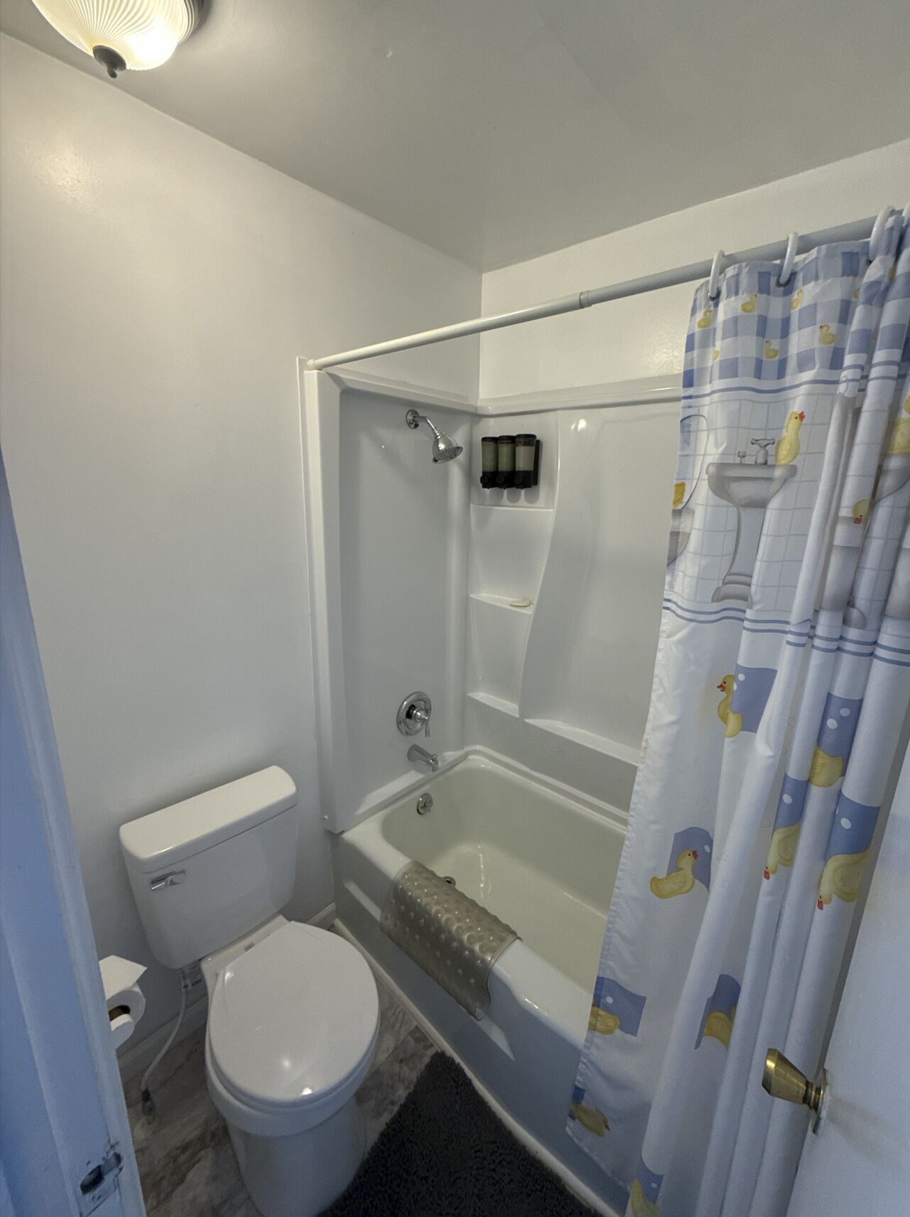 A bathroom with a toilet, a bathtub, and a shower.
