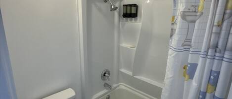 A bathroom with a toilet, a bathtub, and a shower.