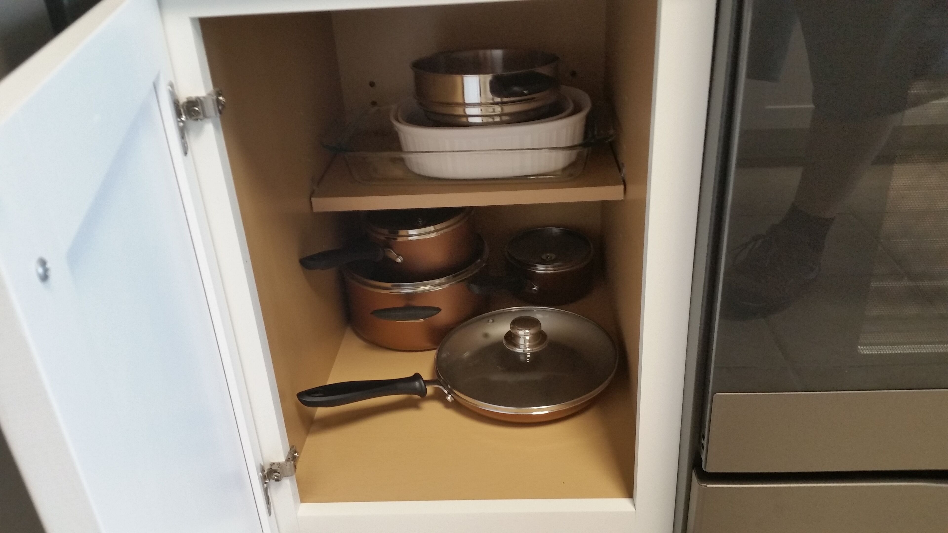 Ein Küchenschrank mit Töpfen und Pfannen.