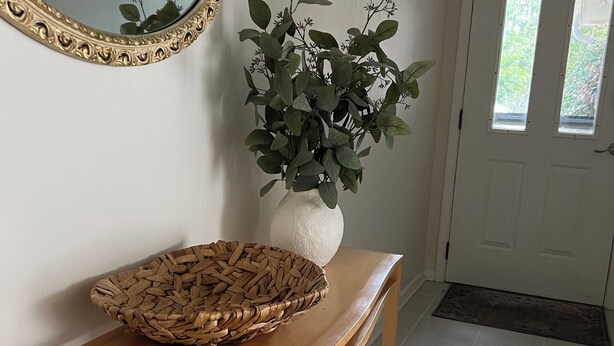 A wooden console table with a woven basket and a potted plant. - Clean and open 3bd/2ba in a quiet close-in neighborhood (Tallahassee)