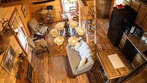 A cozy cabin interior with a dining area, wooden furniture, and a kitchen. - NEW! Custom Cabin on 10 acres! (Sevierville)