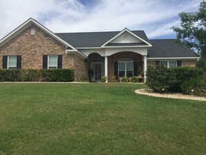 Stunning two-story home with a charming entrance and beautifully manicured grounds.