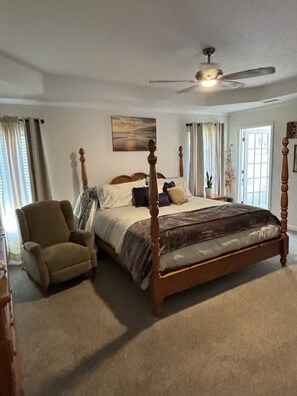 Cozy retreat with a four-poster bed, nightstands, and a modern ceiling fan.
