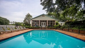 A swimming pool with lounge chairs and a building in the background.
