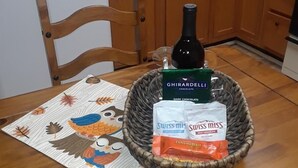 Une cuisine avec des meubles de rangement en bois, un four à micro-ondes et une table agrémentée d’un set de table orné de feuilles d’automne et de hiboux.