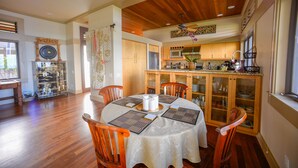 Un coin repas avec une table ronde, des chaises en bois et un ventilateur de plafond.