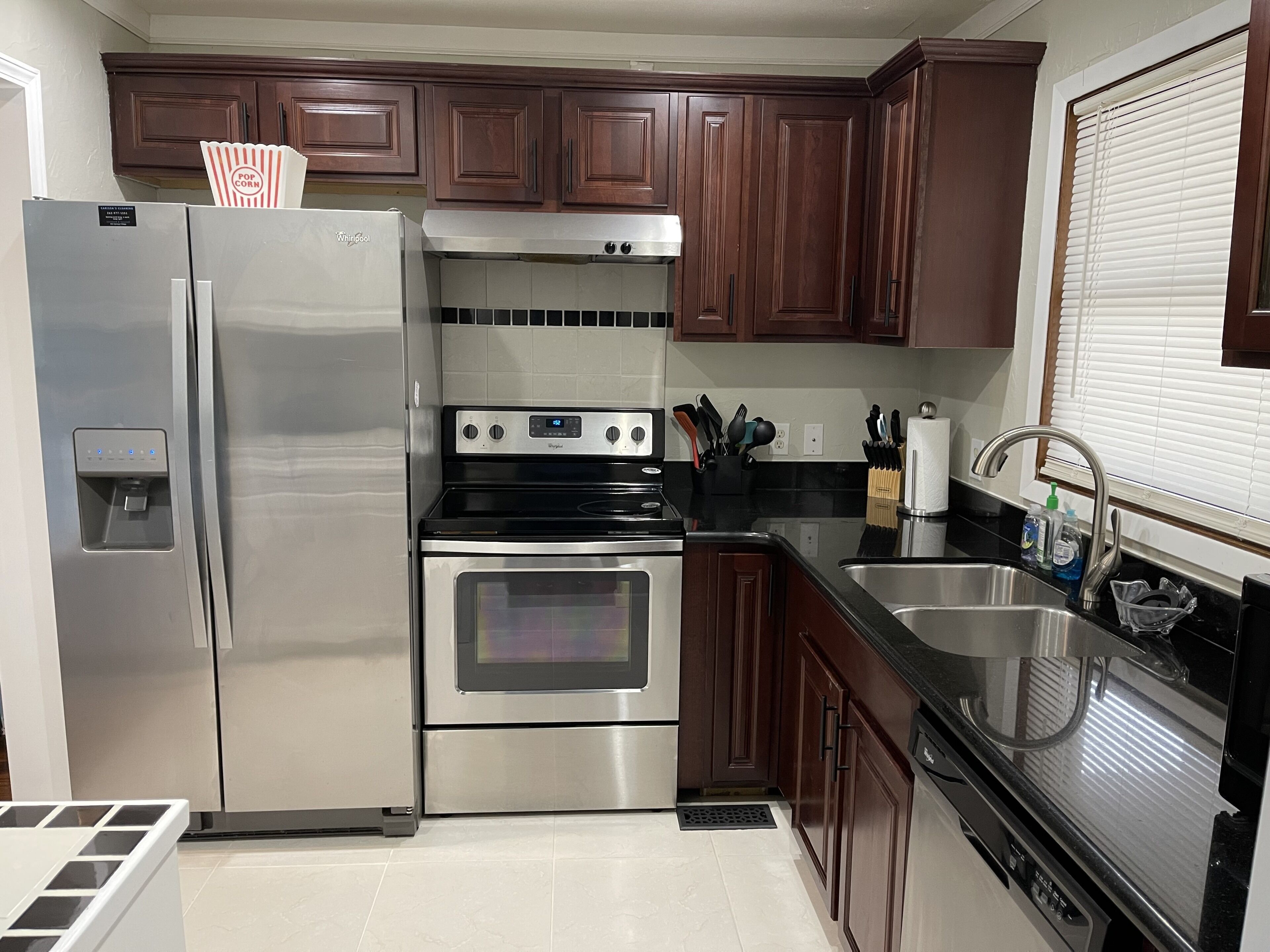 A kitchen with stainless steel appliances, wooden cabinets, a built-in oven, and a sink.