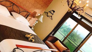 A hotel room with a large bed, a chandelier, a view of greenery, and a window. - Hu Moon Lake (Shoufeng)