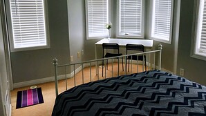 A bedroom with a bed, a desk, two chairs, and three windows with blinds. - Entire 3 Bedroom Townhouse in Markham (Markham)