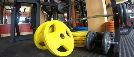 A gym with weightlifting equipment, including a squat rack and various weights.