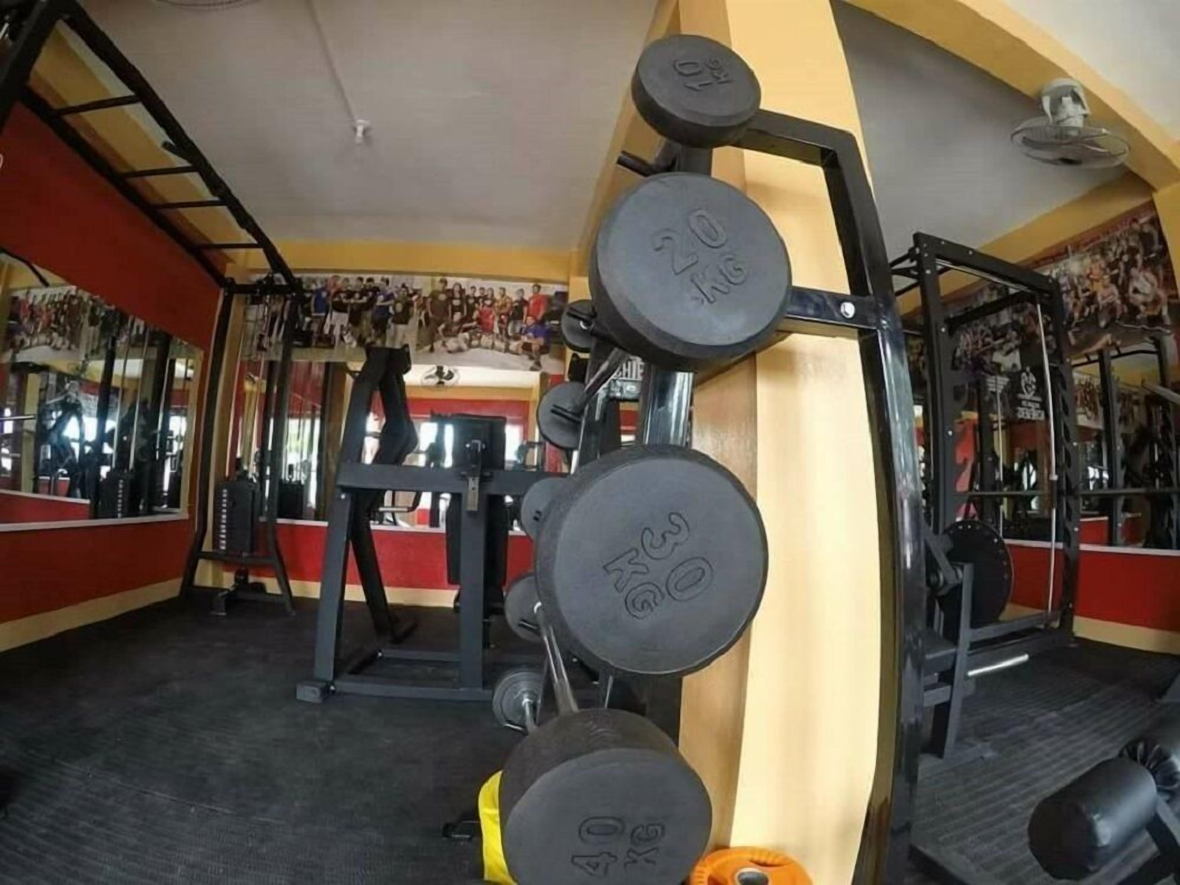 A gym with weightlifting equipment, including dumbbells and a squat rack.