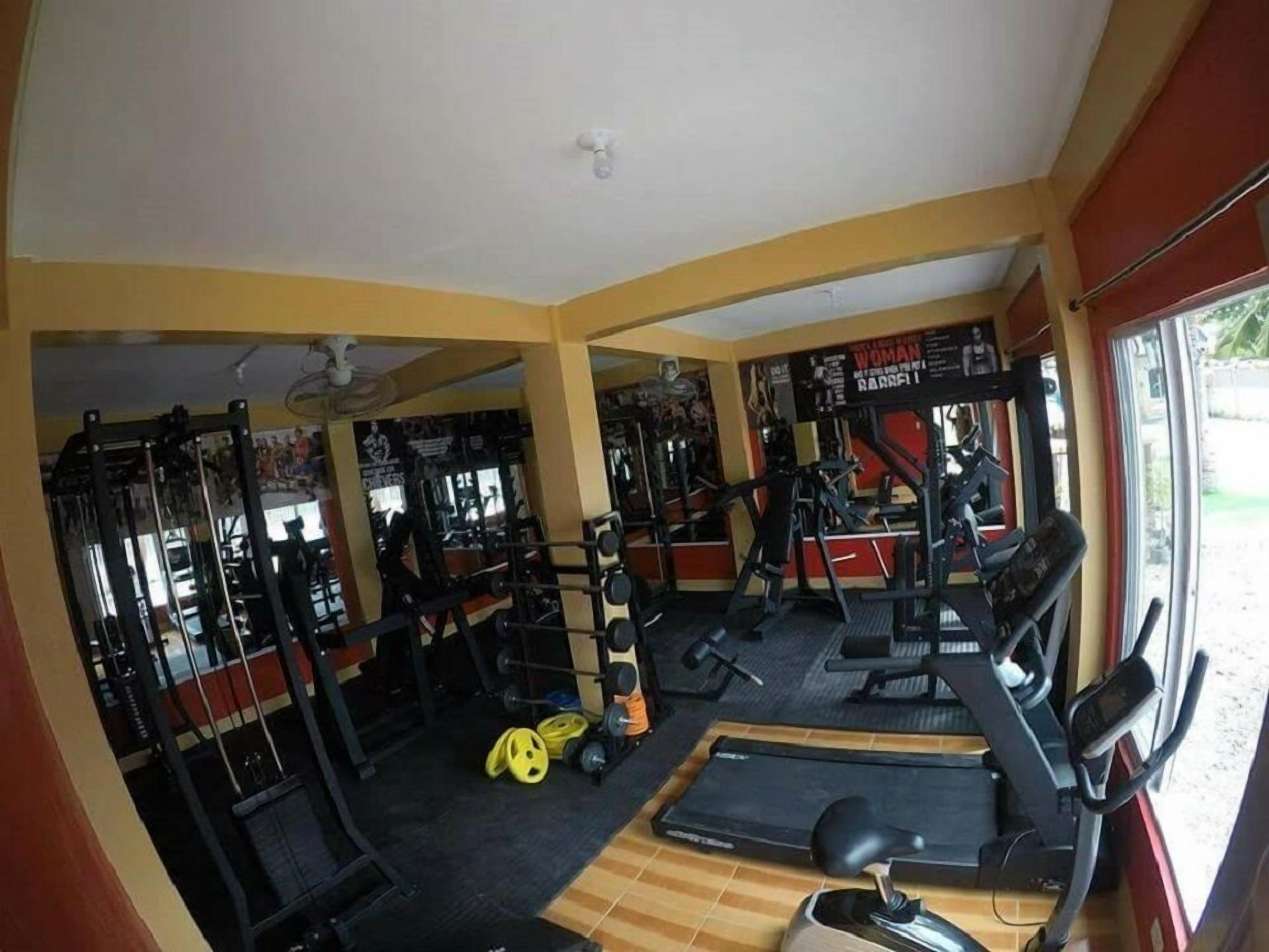 A gym with various exercise equipment, including treadmills, weight machines, and free weights.