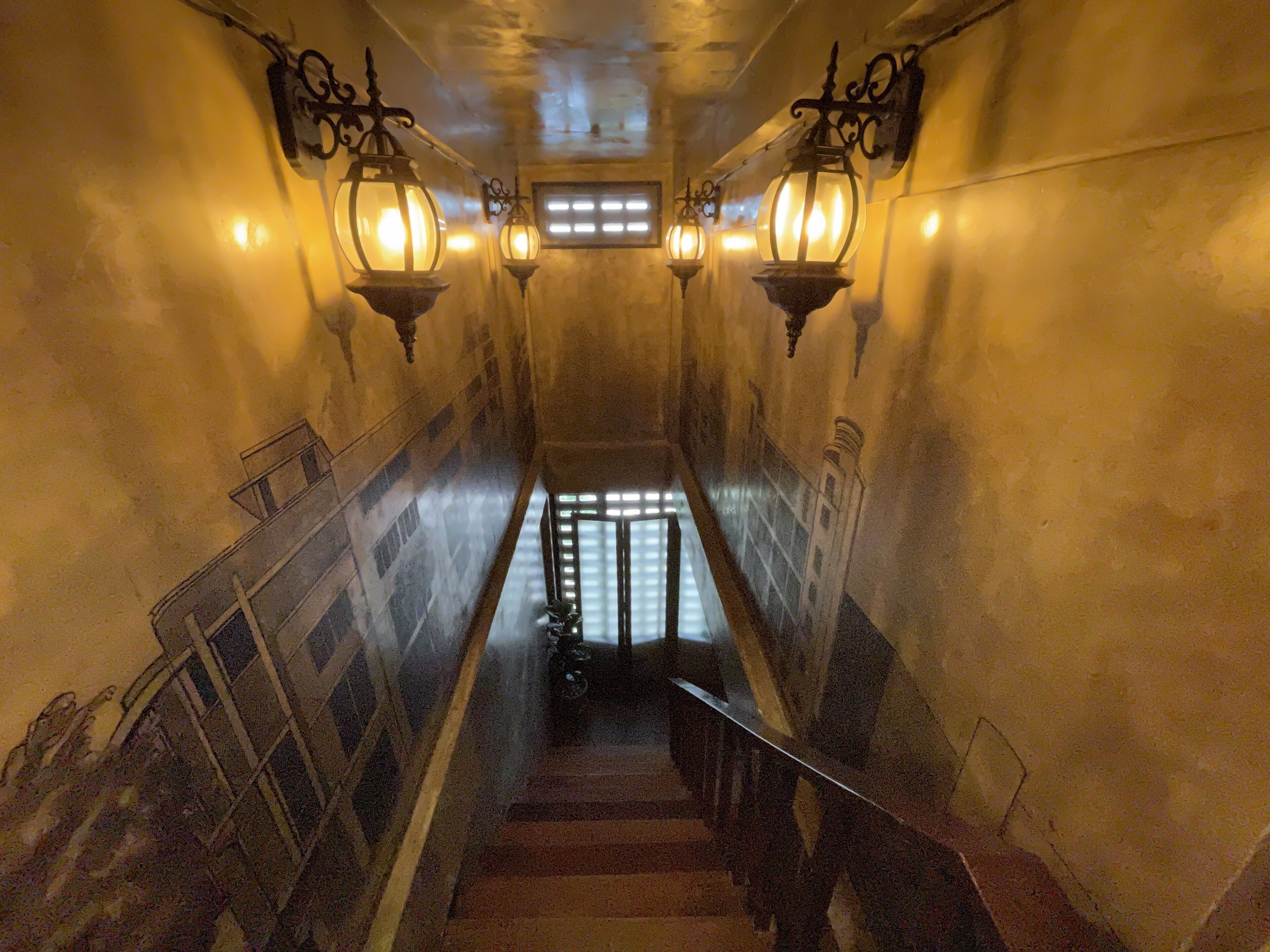 Una scala con luci a parete e una finestra in cima.