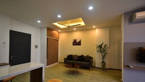 A modern living room with a sofa, coffee table, and a potted plant. - Karta Riverview Apartment (Ho Chi Minh City)