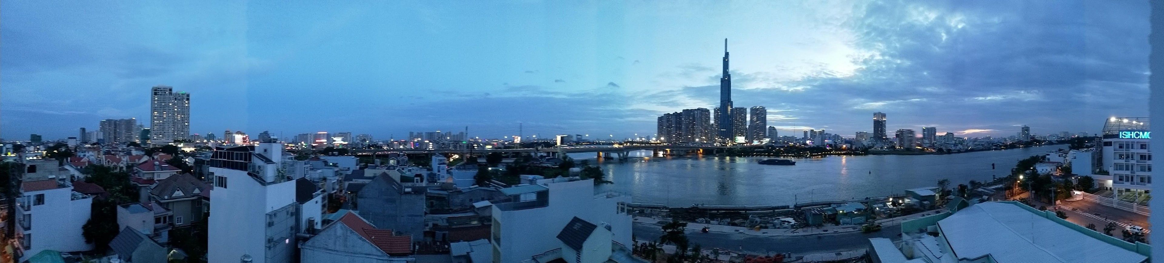 A cityscape with a prominent skyscraper, a river, and surrounding residential buildings.