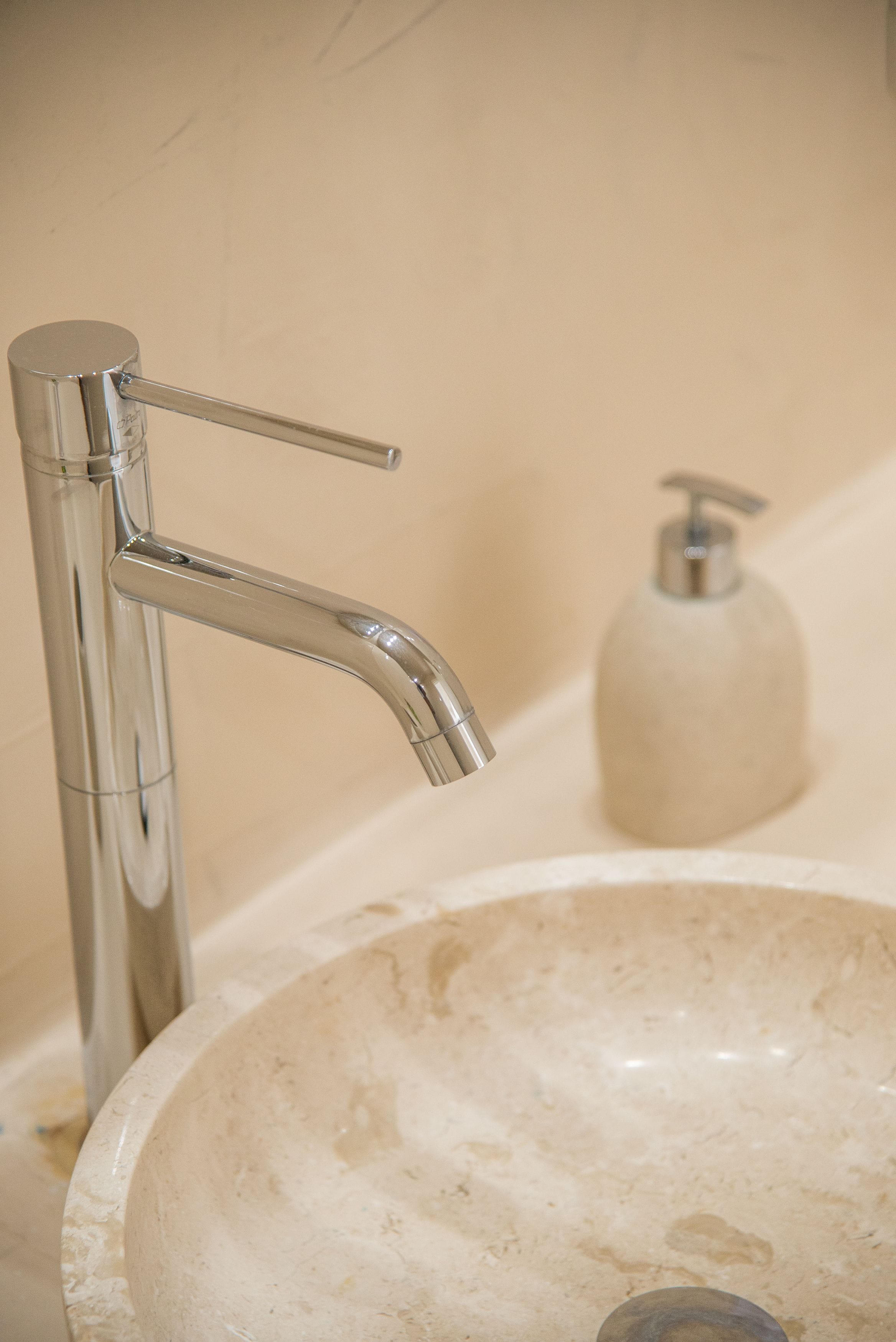 A bathroom sink with a chrome faucet and a soap dispenser.