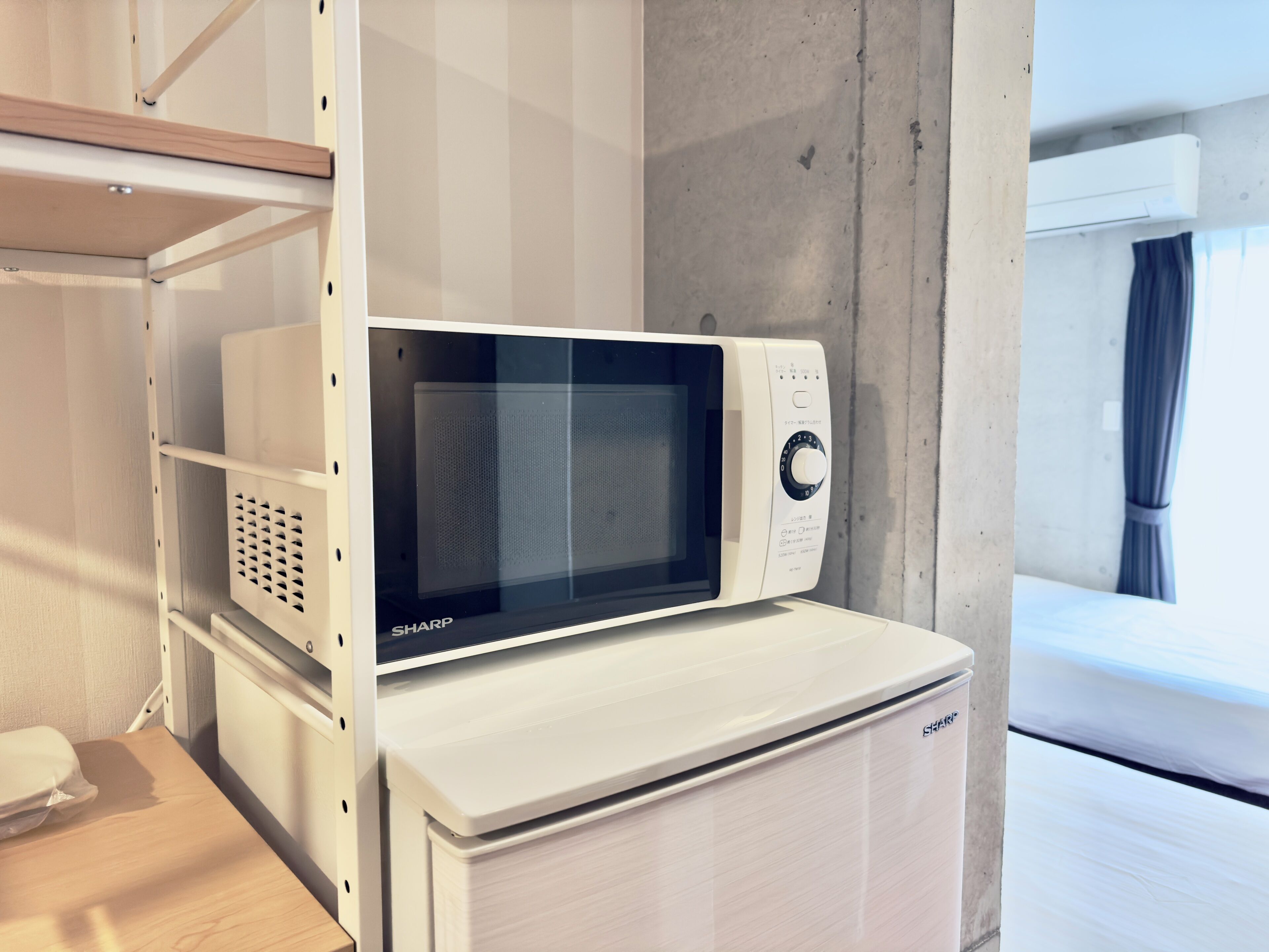 Un microondas sobre una encimera blanca en una habitación de hotel.