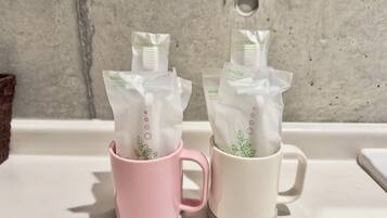 Two mugs with packages of personal care items.