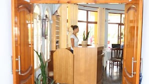 A kitchen area with wooden cabinets, a countertop, and a potted plant. - Hotel Alpine (Vlorë)