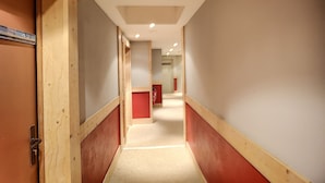 A hallway with wooden paneling, a red door, and a sign indicating room number 422.