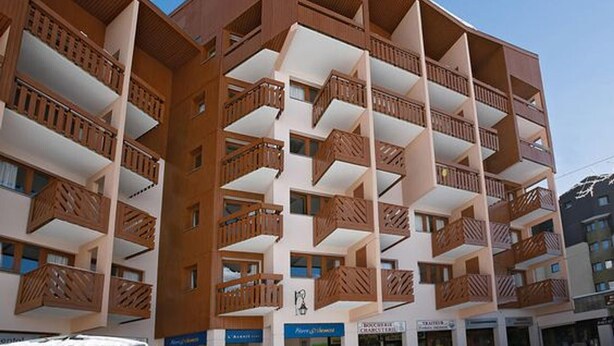 A multi-story hotel with balconies and a clear sky.