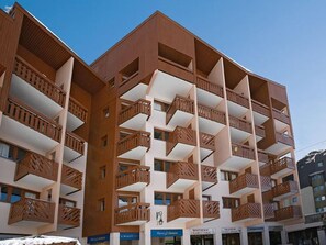 A multi-story hotel with balconies and a clear sky.
