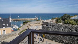 A coastal view with a lighthouse, boats, and a stone wall. - Central apartment with sea view terrace, pets allowed (Le Palais)