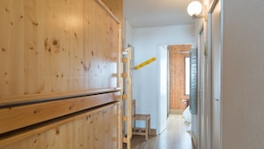 A wooden interior hallway with a wooden door, a chair, and a window. - Tignes Apartment, 2 rooms, 500m from slopes (Tignes)