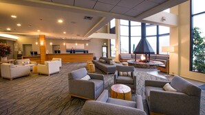 A spacious lobby with multiple seating areas, a reception desk, and a fireplace.