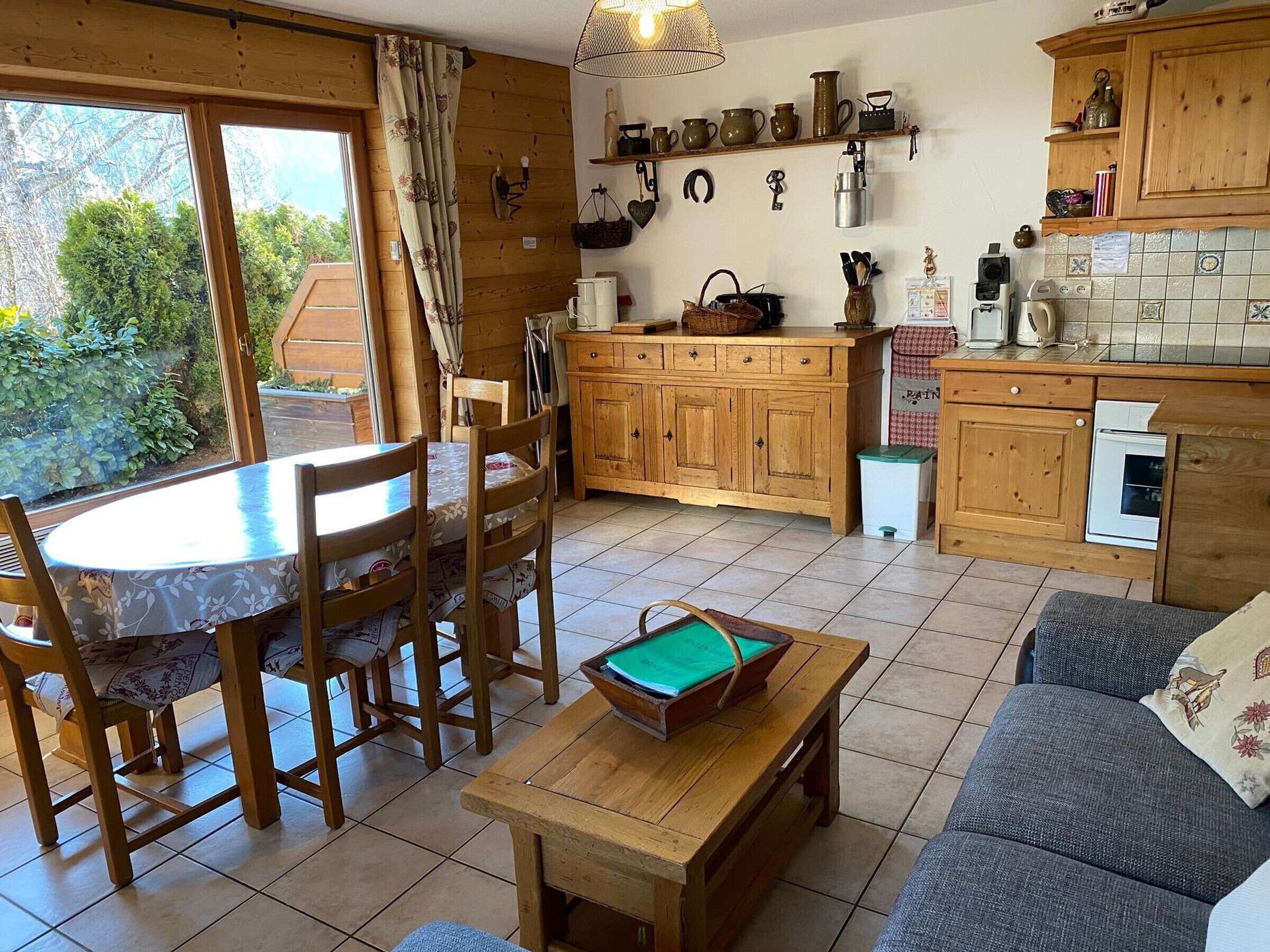 A cozy kitchen with wooden cabinets, a dining table with chairs, a small sofa, and a pool table.