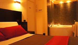 Una habitación de hotel con cama, baño con bañera y ducha.