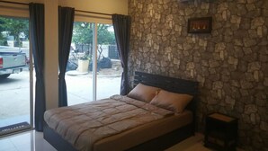 Un dormitorio con pared de piedra, una cama y un equipo de aire acondicionado.