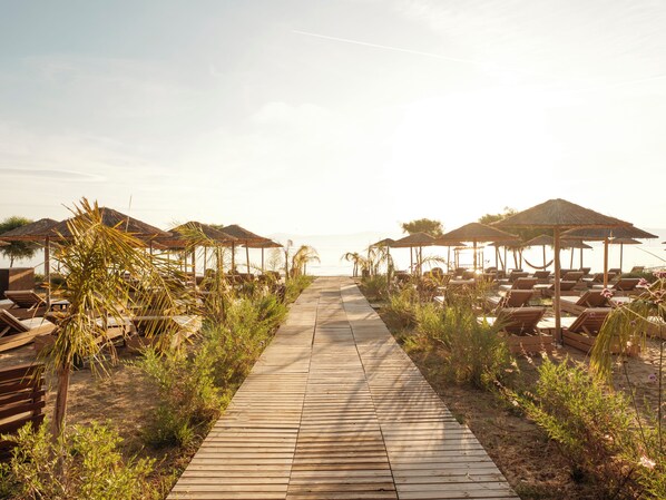 A wooden pathway leading to beach umbrellas and lounge chairs. - AYLA by Ekati Mare (Corfu)