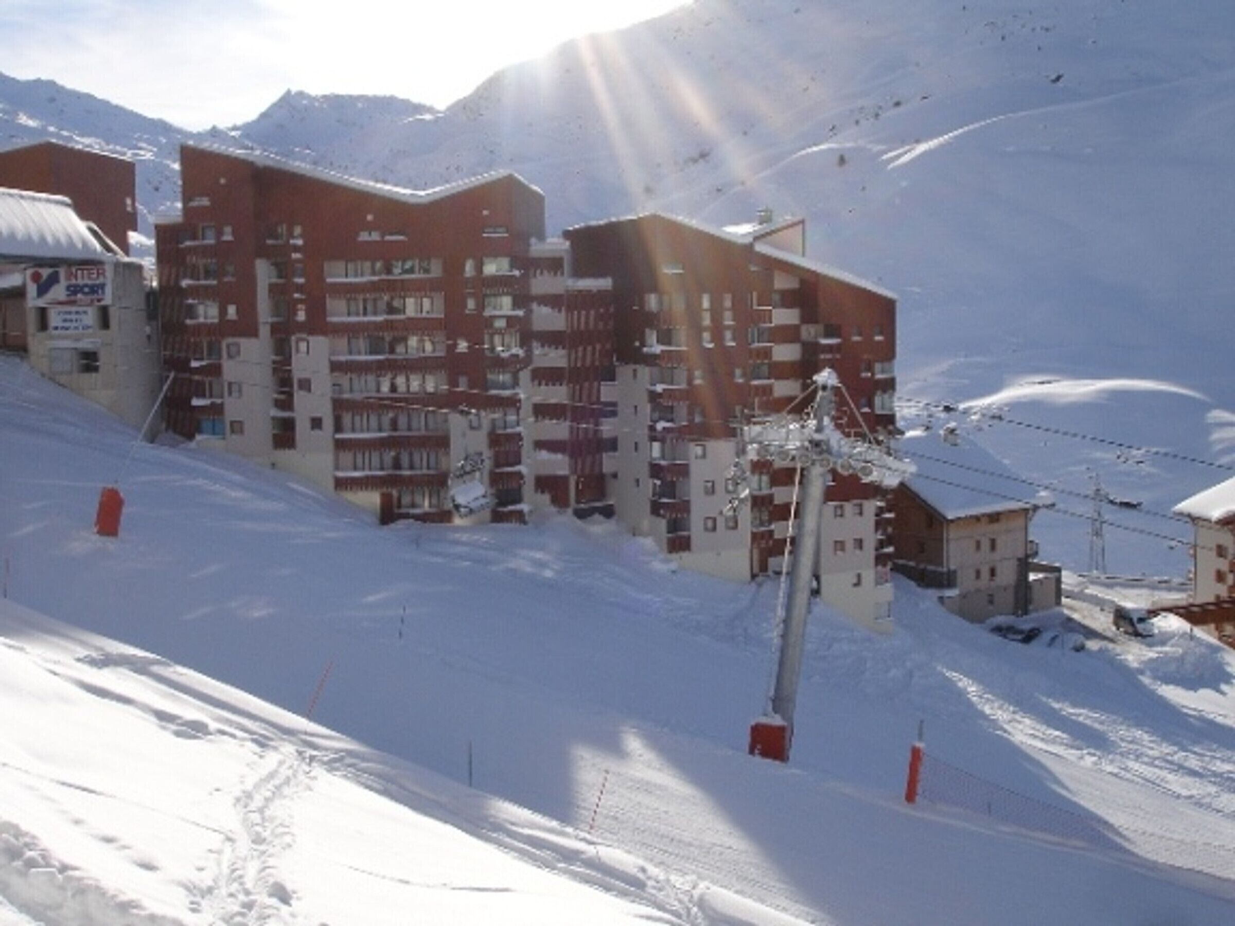 Un hotel a più piani con una pista da sci sullo sfondo.