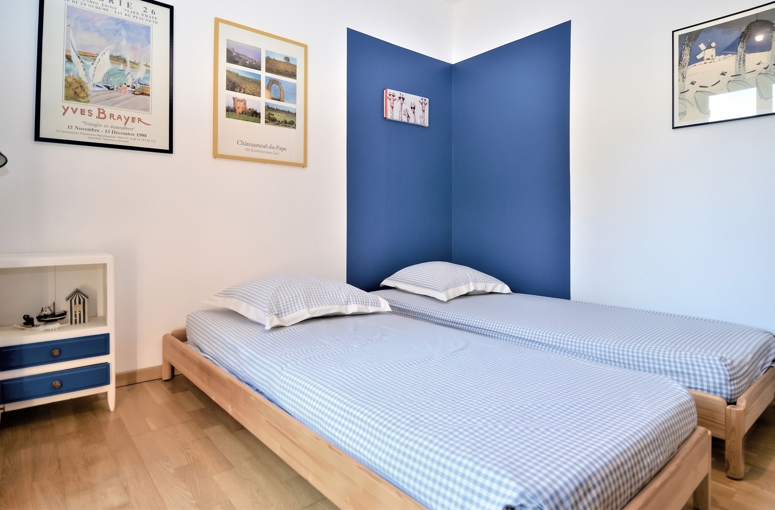 Ein Schlafzimmer mit zwei Einzelbetten, einem Nachttisch und einer Kommode.