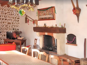 A cozy room with a fireplace, stone wall, wooden furniture, and a painting of 'The Last Supper'. - Homerez - House in Bernac-Dessus (Bernac-Dessus)