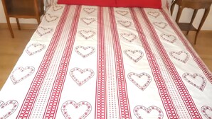 A bed with a red and white patterned bedspread, two bedside tables with lamps, and a wooden floor. - Homerez - House in Bernac-Dessus (Bernac-Dessus)